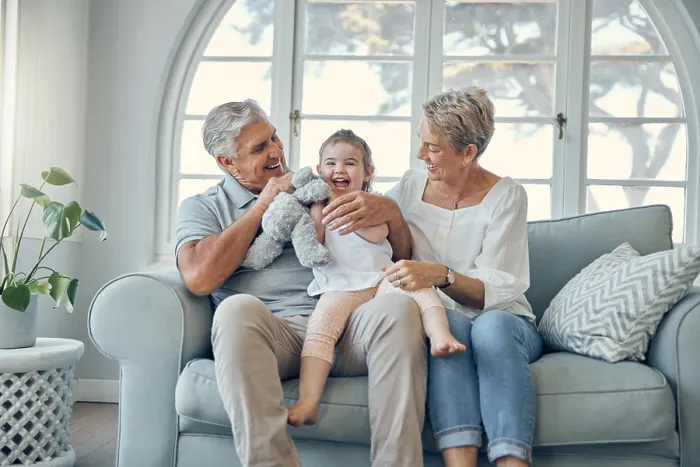 Framed Print : Happy family, grandparents and baby on sofa together talking Framed Print : Happy family, grandparents and baby on sofa together talking