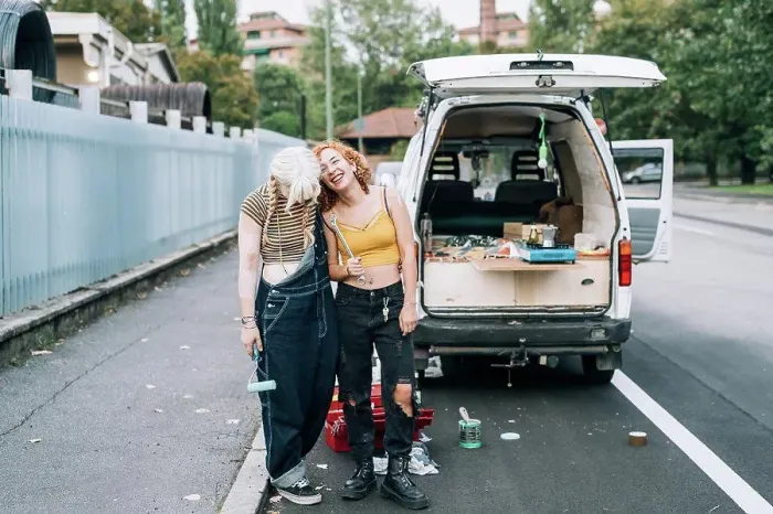 Framed Print : Happy female couple, standing near their van