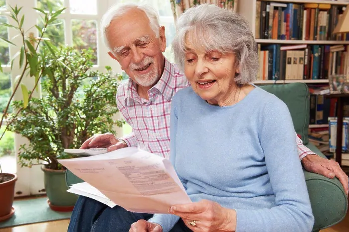 Framed Print : Happy Senior Couple Reviewing Finances At Home Framed Print : Happy Senior Couple Reviewing Finances At Home