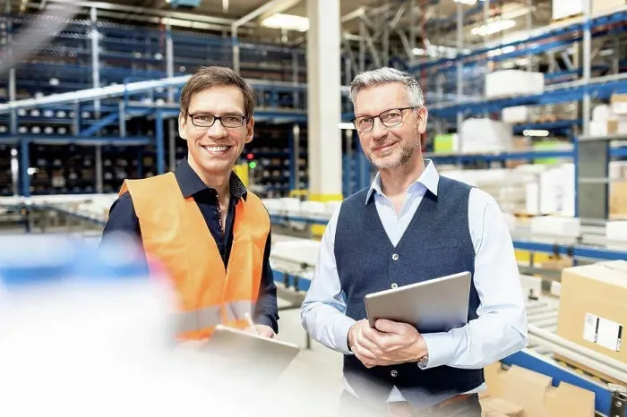 Framed Print : Happy worker standing by manager holding tablet PC in warehouse Framed Print : Happy worker standing by manager holding tablet PC in warehouse