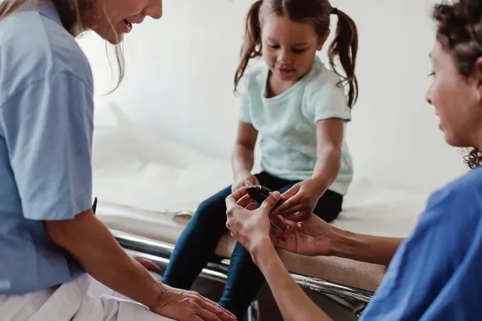 Framed Print : Healthcare worker showing glaucometer to girl by doctor in clinic Framed Print : Healthcare worker showing glaucometer to girl by doctor in clinic
