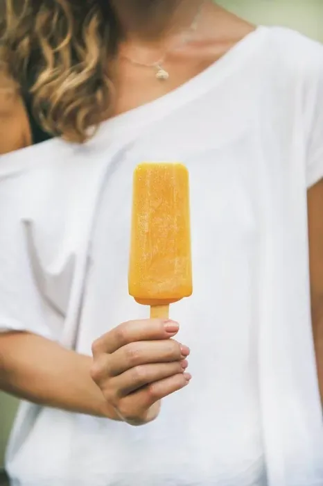 Framed Print : Healthy vegan orange mango citrus ice cream popsicle in hand of young woman