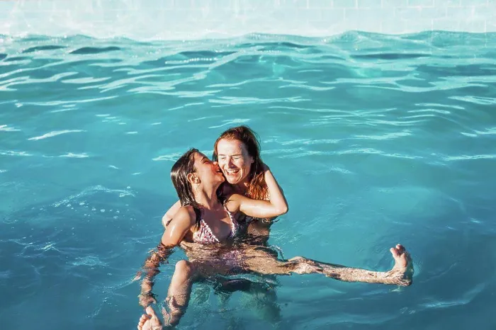 Framed Print : High angle view of girl kissing happy mother in swimming pool