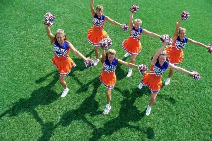 Framed Print : High angle view of a group of cheerleaders cheering in a field