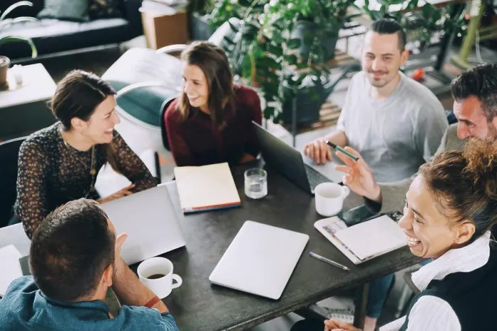 Framed Print : High angle view of happy business people sitting at table in creative office