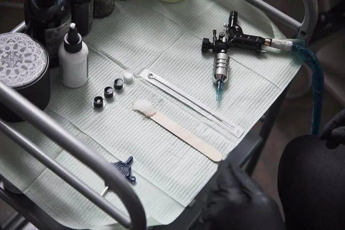 Framed Print : High angle view of tattoo artist sitting by tools on table Framed Print : High angle view of tattoo artist sitting by tools on table
