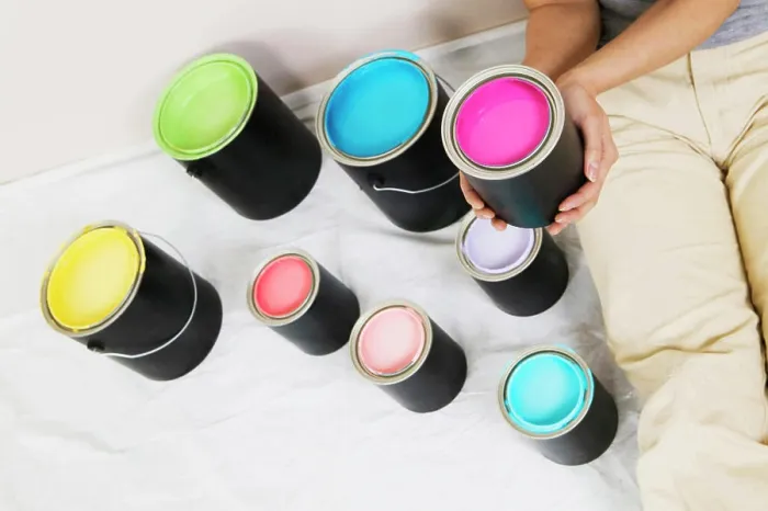 Framed Print : High angle view of a woman sitting with paint cans beside her Framed Print : High angle view of a woman sitting with paint cans beside her