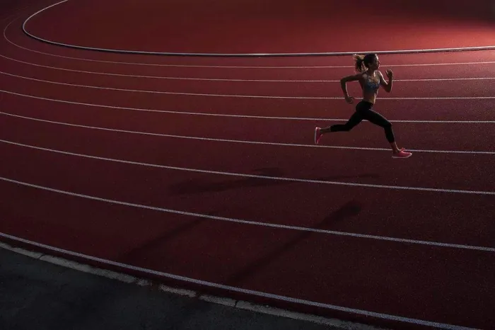 Framed Print : High angle view of young female athlete running on race track Framed Print : High angle view of young female athlete running on race track