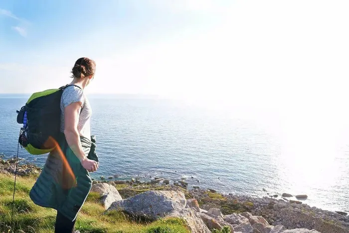 Framed Print : Hiker with backpack on cliff looking at view of ocean, Portland, UK Framed Print : Hiker with backpack on cliff looking at view of ocean, Portland, UK