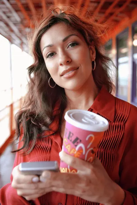 Framed Print : Hispanic businesswoman holding coffee and cell phone Framed Print : Hispanic businesswoman holding coffee and cell phone