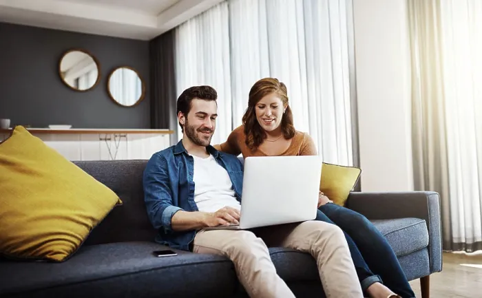 Framed Print : Home, smile and couple with laptop on sofa for online travel booking Framed Print : Home, smile and couple with laptop on sofa for online travel booking