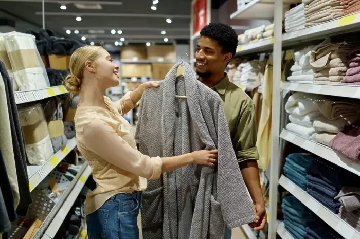 Framed Print : Interracial family couple customer choosing bathrobe in shop