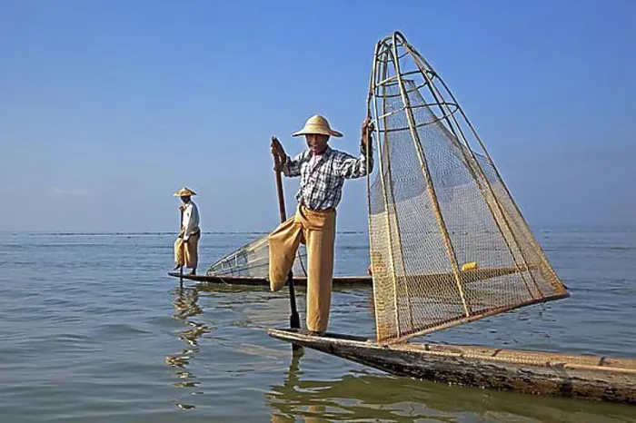 Framed Print : Two Intha fishermen steering traditional fishing boats by wrapping their leg around the oar Framed Print : Two Intha fishermen steering traditional fishing boats by wrapping their leg around the oar
