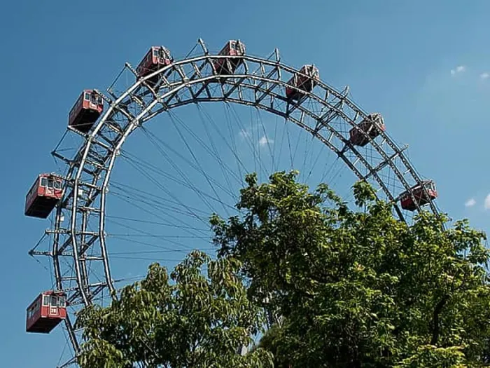 Framed Print : Large Ferris wheel with red cabins behind trees in an amusement park under a blue sky, Vienna, Austria, Europe Framed Print : Large Ferris wheel with red cabins behind trees in an amusement park under a blue sky, Vienna, Austria, Europe
