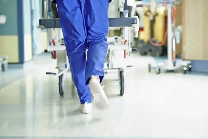 Framed Print : Legs of medic running with gurney along hospital corridor