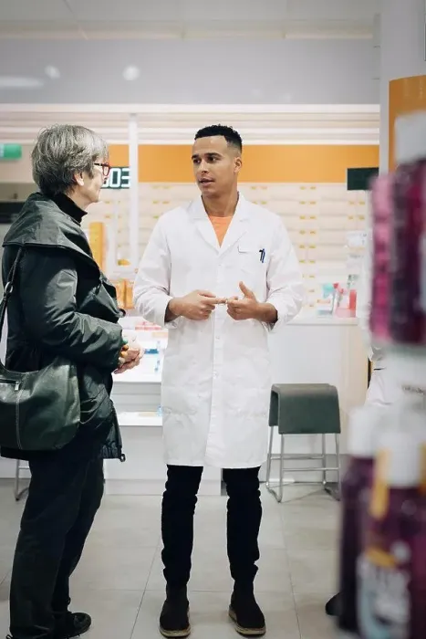 Framed Print : Full length of male pharmacist talking with senior female customer in medical store