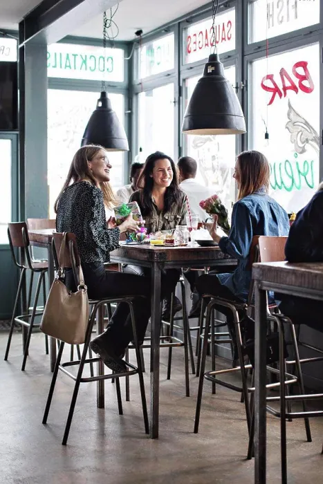 Framed Print : Full length of smiling female friends sitting with birthday presents at dining table in restaurant Framed Print : Full length of smiling female friends sitting with birthday presents at dining table in restaurant