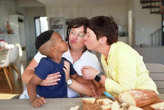 Framed Print : Lesbian couple and cute son puckering lips at dinner table Framed Print : Lesbian couple and cute son puckering lips at dinner table