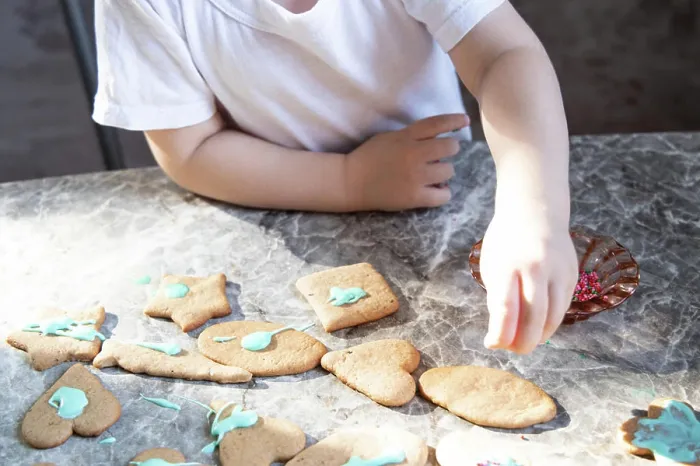Framed Print : Little boy is decorating ginger cookies on the kitchen Framed Print : Little boy is decorating ginger cookies on the kitchen