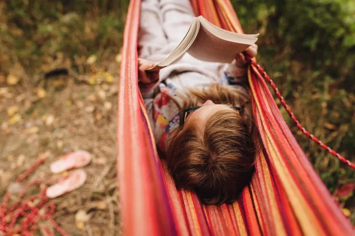 Framed Print : Little girl reads a book in hammock on a warm fall day while camping Framed Print : Little girl reads a book in hammock on a warm fall day while camping