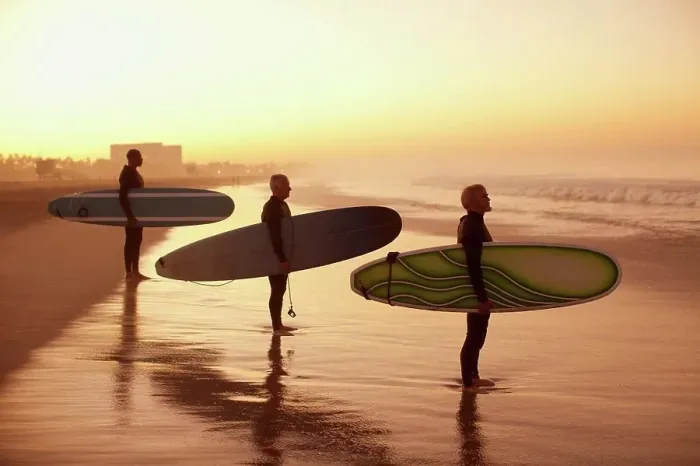 Framed Print : Los Angeles, USA, Surfers holding boards on beach