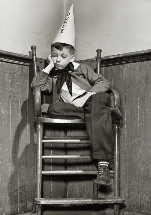Framed Print : Low angle view of a boy wearing a dunce cap Framed Print : Low angle view of a boy wearing a dunce cap