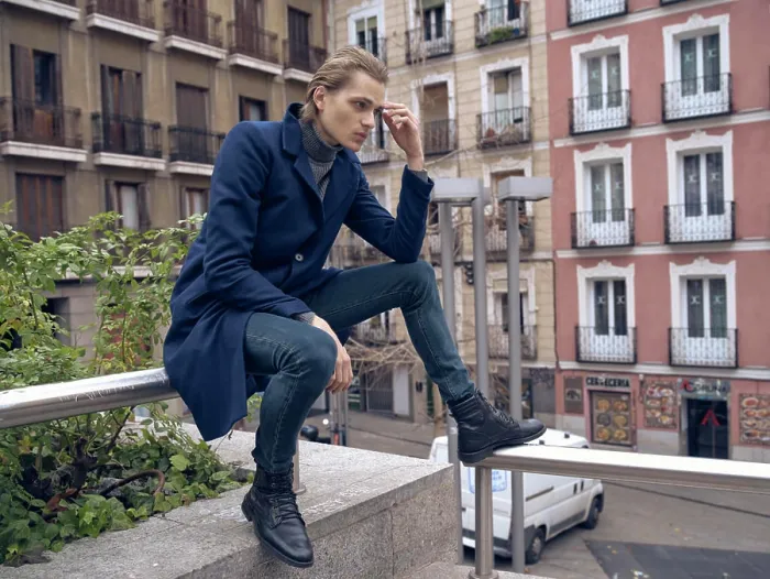 Framed Print : Low angle side view of serious elegant young male in stylish coat leaning on hand