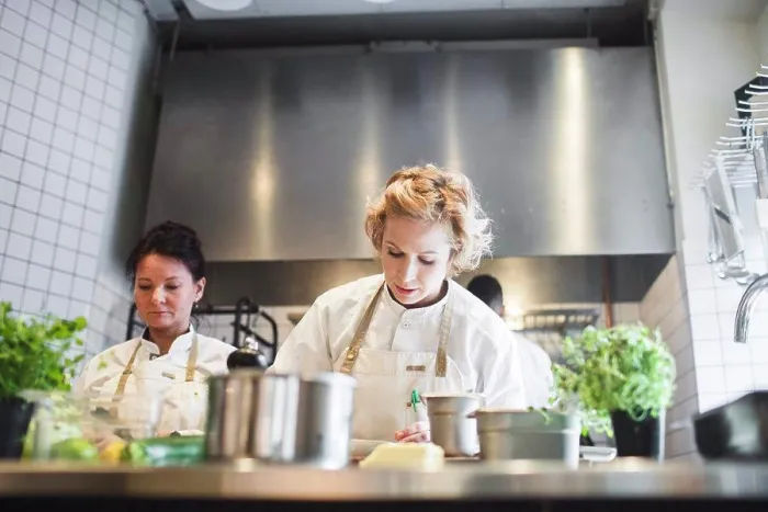 Framed Print : Low angle view of female chefs working at kitchen counter in restaurant Framed Print : Low angle view of female chefs working at kitchen counter in restaurant