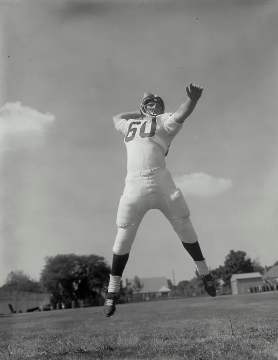 Framed Print : Low angle view of a football player throwing a football