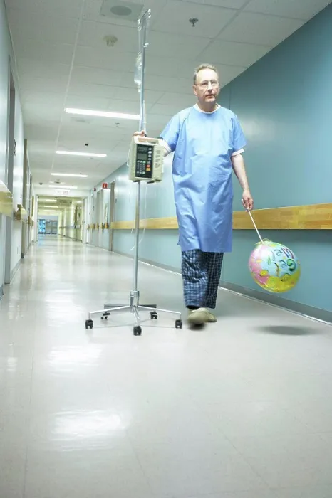 Framed Print : Low angle view of a male patient walking with an IV drip stand Framed Print : Low angle view of a male patient walking with an IV drip stand