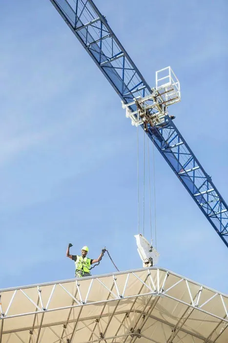 Framed Print : Low angle view of successful worker standing on roof at construction site Framed Print : Low angle view of successful worker standing on roof at construction site