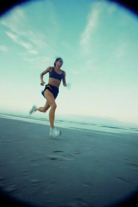 Framed Print : Low angle view of a young woman running on the beach