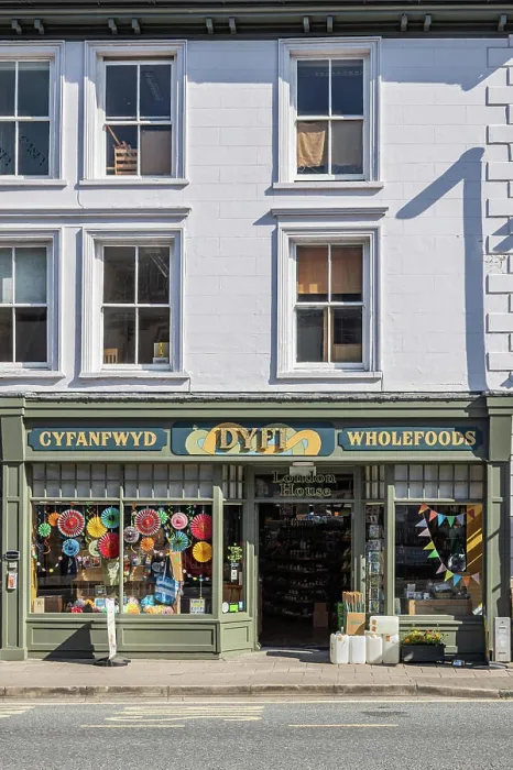 Framed Print : Machynlleth, Powys, Wales, United Kingdom. May 1, 2025. Small shop advertising Whole Foods in Welsh and English Framed Print : Machynlleth, Powys, Wales, United Kingdom. May 1, 2025. Small shop advertising Whole Foods in Welsh and English