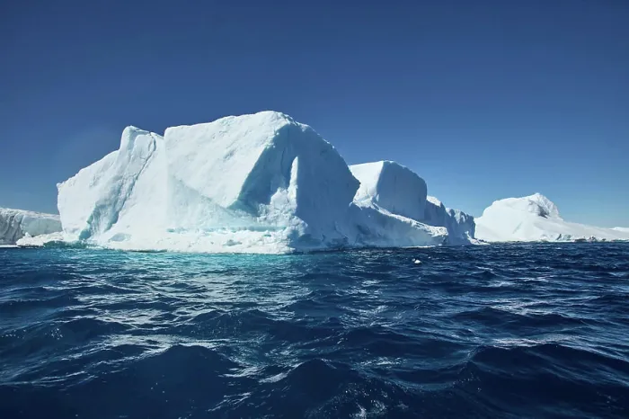 Framed Print : Majestic iceberg floating in a clear blue ocean under a bright sky