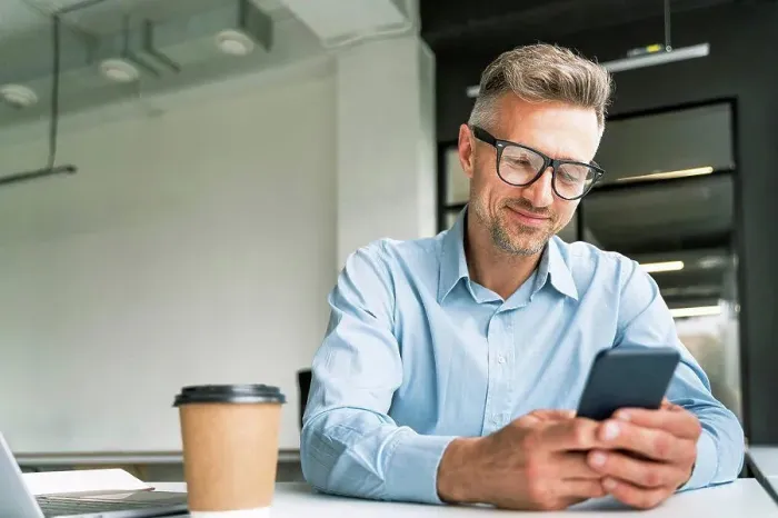 Framed Print : Male business professional using smart phone in office Framed Print : Male business professional using smart phone in office
