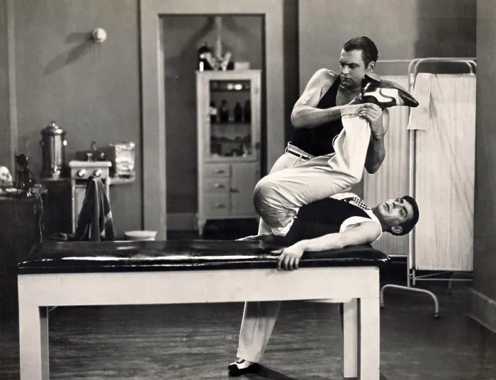 Framed Print : Male contortionist stretching legs of a patient Framed Print : Male contortionist stretching legs of a patient