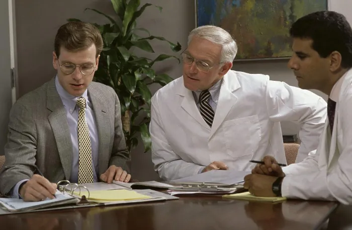 Framed Print : Three male doctors talking in a conference room Framed Print : Three male doctors talking in a conference room