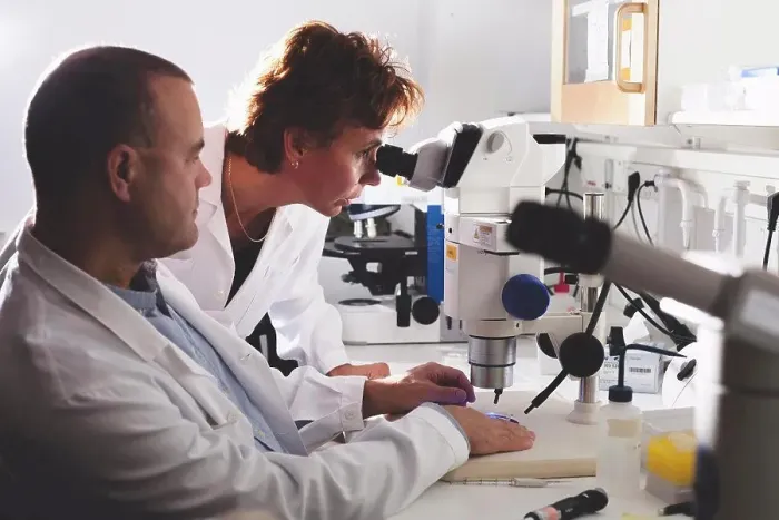 Framed Print : Male and female scientists using microscope in laboratory Framed Print : Male and female scientists using microscope in laboratory