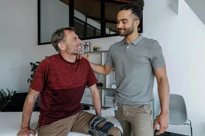 Framed Print : Male physiotherapist with smiling patient in medical practice Framed Print : Male physiotherapist with smiling patient in medical practice