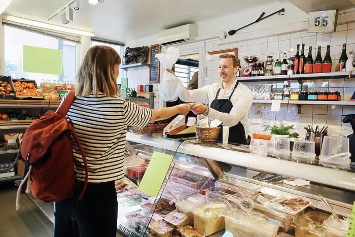Framed Print : Male sales clerk holding plastic bag while accepting credit card from customer at checkout counter Framed Print : Male sales clerk holding plastic bag while accepting credit card from customer at checkout counter