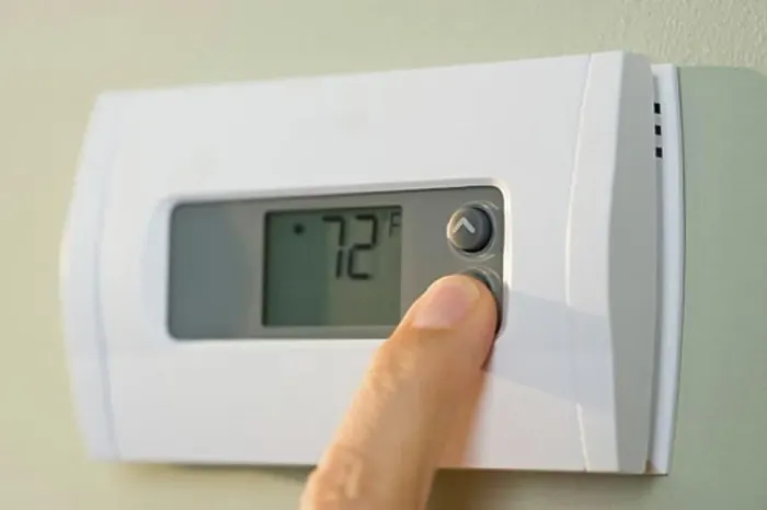 Framed Print : Man adjusting thermostat