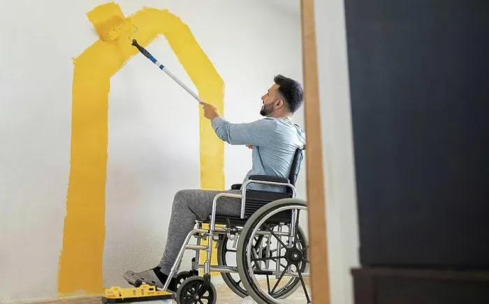 Framed Print : Man with disability painting wall through paint roller at home Framed Print : Man with disability painting wall through paint roller at home