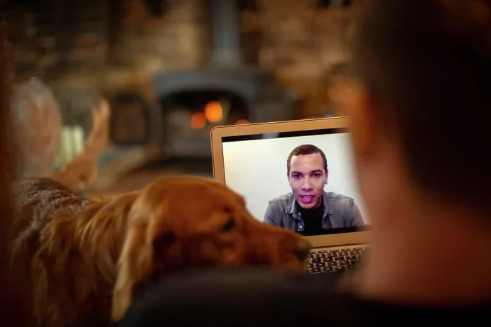 Framed Print : Man with dog video chatting with colleague on laptop screen Framed Print : Man with dog video chatting with colleague on laptop screen