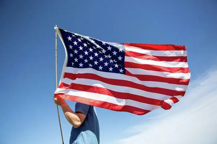 Framed Print : Man holding American flag under blue sky Framed Print : Man holding American flag under blue sky