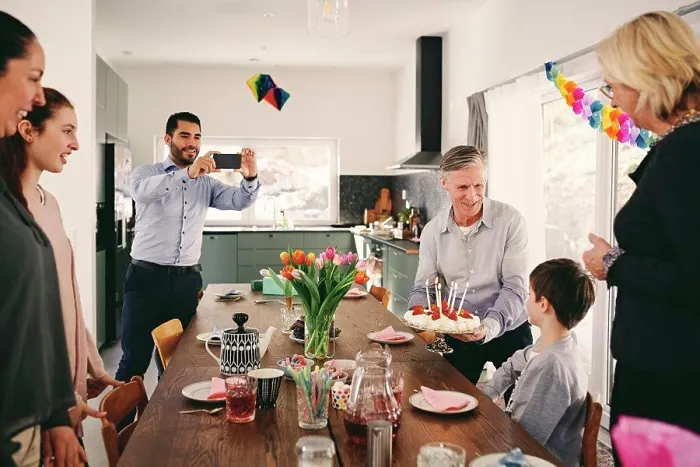 Framed Print : Man photographing boy with family during birthday party through smart phone Framed Print : Man photographing boy with family during birthday party through smart phone