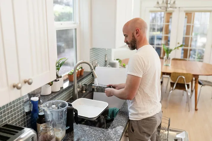 Framed Print : Man rinsing dishes in kitchen Framed Print : Man rinsing dishes in kitchen