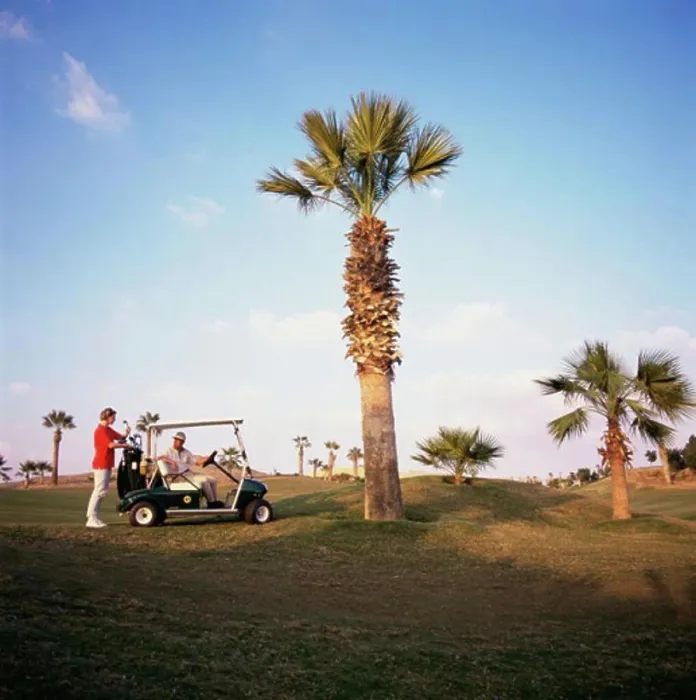 Framed Print : Man sitting on a golf cart with a woman standing behind him, Sharm el Sheikh, Egypt Framed Print : Man sitting on a golf cart with a woman standing behind him, Sharm el Sheikh, Egypt