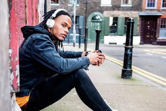 Framed Print : Man sitting in street listening to music through headphones Framed Print : Man sitting in street listening to music through headphones