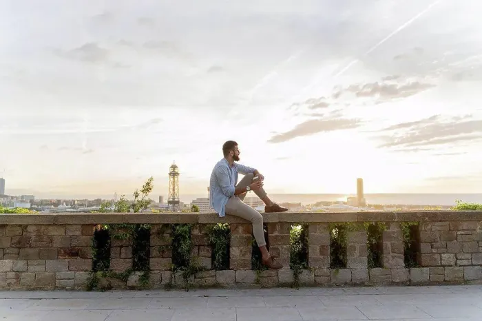 Framed Print : Man sitting on a wall on lookout above the city with view to the port, Barcelona, Spain Framed Print : Man sitting on a wall on lookout above the city with view to the port, Barcelona, Spain