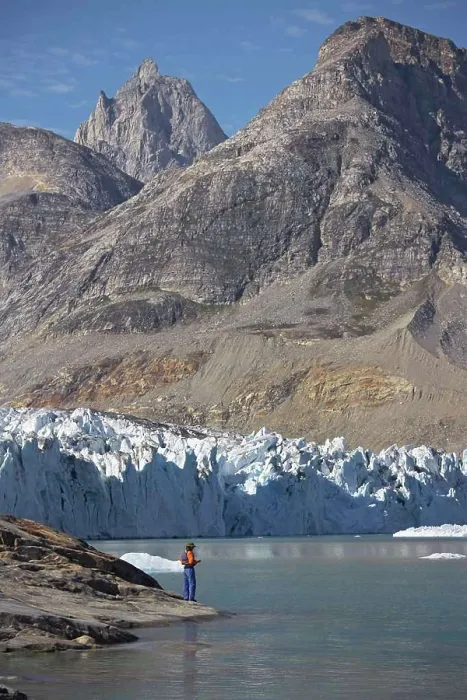 Framed Print : man standing at the water's edge of a fjord in Greenland Framed Print : man standing at the water's edge of a fjord in Greenland